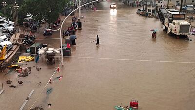 People wade through floodwater in Zhengzhou.