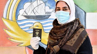 A Kuwaiti woman wearing a protective masks waits to cast her votes at a polling station in Kuwait City. EPA
