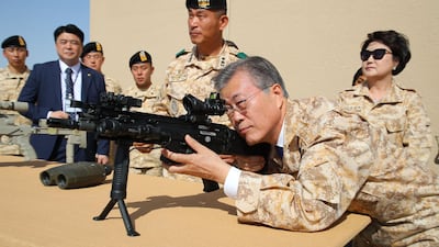 South Korean President Moon Jae-in takes up a shooting position as he visits a contingent of the Akh unit, a South Korean military detachment stationed in Abu Dhabi. Moon is on a four-day visit to the UAE. EPA / Yonhap