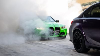 A bright green M3 lurks amid tyre smoke.