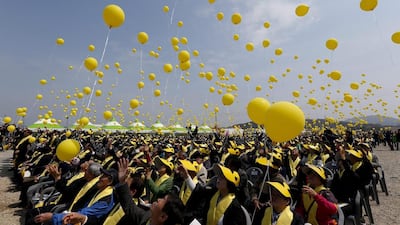 Yellow balloons fly yesterday to commemorate the victims of the Sewol ferry sinking one year ago. News that the ferry will be lifted from its grave has not assuaged the grief or appeased the anger of many mourning the 300 people who drowned. Jeon Heon-Kyun / EPA