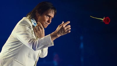 Brazilian singer-songwriter Roberto Carlos throws a rose to his fans as he performs in Rio de Janeiro. AFP