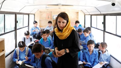 Freshta Karim, founder of the mobile library bus, checks on school boys on a mobile library bus.
