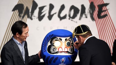 France's hooker Guilhem Guirado paints on a Japanese daruma doll at the Kawaguchiko theatre. AFP