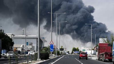 Motorists in Doha drive past a pall of smoke rising from what was reported to have been an Iranian strike on an industrial district of the Qatari capital. Tehran says its actions were in pursuit of US military installations and assets. AFP