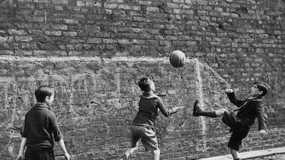 A group of boys playing football in the street in Salford in 1938. Who needs goalposts when you could paint them on the wall? Getty Images