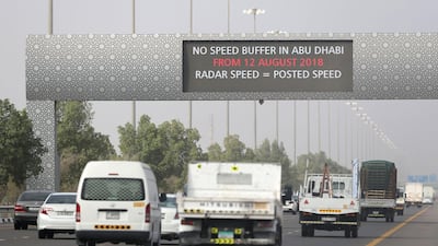 Commuters drive to Abu Dhabi from Dubai as a sign warns motorists that the speed buffer has been removed in the capital. Chris Whiteoak / The National