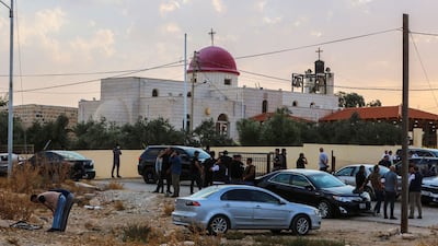 People and security forces outside the Greek Orthodox Church in the village of Hammoud. AFP