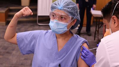 Physician Joyce Limurti, 40, flexes her bicep as she is given the coronavirus disease (COVID-19) vaccine at Dignity Health Glendale Memorial Hospital and Health Center in Glendale, California, U.S. REUTERS