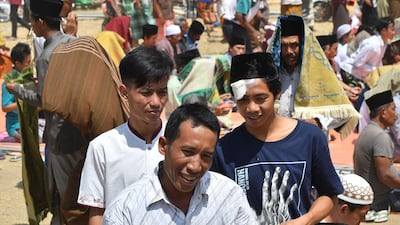 Indonesian Muslims disperse following congregational Friday prayers on a field near temporary shelters in Pemenang, northern Lombok. AFP