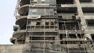 Workers clear debris from the damaged building to allow repair work to begin