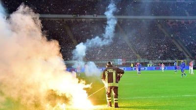 A firefighter removes flares thrown by visiting Croatia fans at the San Siro in Milan on Sunday night during the Croatia-Italy Euro 2016 qualifying match. Giuseppe Cacace/ AFP / November 16, 2014