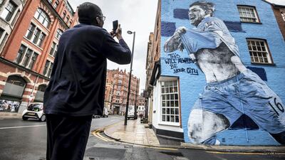 A fan takes a picture of a new mural featuring Manchester City striker Sergio Aguero, as excitement builds in in the city before the club's Champions League final appearance. Darren Robinson for The National