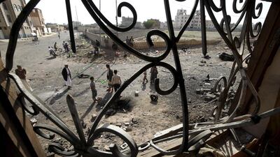 People are pictured through a damaged window of a house, near the site of Thursday's car bomb attack in Sanaa on August 14. Reuters