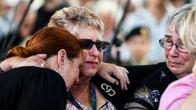 Women embrace as they attend the 10th anniversary memorial service. AP Photo