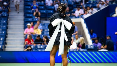 Naomi Osaka wearing a fitted black tiered, ruffled skirt with oversized white bow before her second-round match at the 2024 US Open. Getty Images