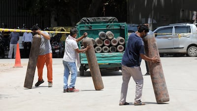 Indian people after getting their oxygen cylinders refilled from an oxygen filling plant in New Delhi, India. EPA