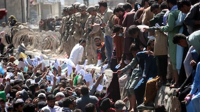 Afghans struggle to reach foreign forces in an attempt to flee the country at Hamid Karzai International Airport in Kabul. EPA