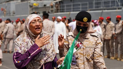 A Saudi Royal Navy officer assists a women evacuated to the kingdom from Sudan on Monday. Reuters