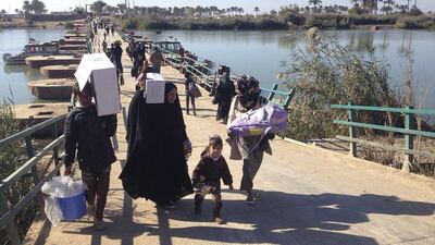 Displaced civilians from Ramadi cross the Bzebiz bridge as they leave their hometowns towards Baghdad, outside Ramadi, the capital of Iraq's Anbar province on December 7, 2015. Residents in Ramadi are trapped as Iraq forces close in on the ISIL-controlled city. Osama Sami/AP Photo