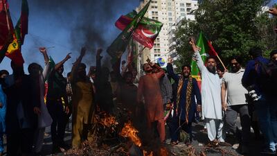 Supporters of Mr Khan block a road during a protest against his arrest. AFP