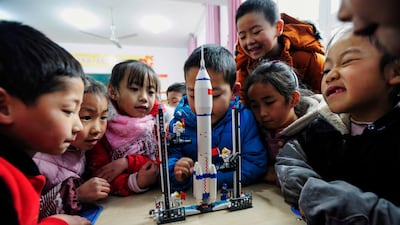 Children look at a model of the Longmarch rocket during an aerospace education lesson at a primary school in Yunyang county in southwestern China's Chongqing. AFP