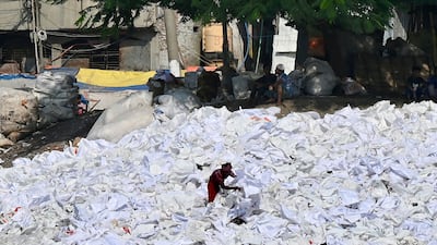 Workers sort plastics for drying, which will be recycled, on the banks of the Buriganga River in Dhaka, Bangladesh. AFP