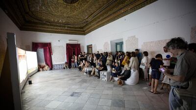 Visitors watching Naeem Mohaiemen's 'Two Meetings and a Funeral" in the Ottoman-era palace that was the venue for the "air" pavilion at Jaou Tunis 