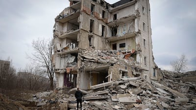 A man looks at his home in a damaged apartment building in Izium, Kharkiv. AP