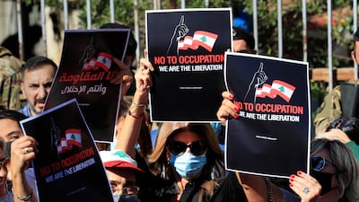 Activists supporting the families of those who were killed in the port blast last year hold placards during a protest in solidarity with Judge Tarek Bitar. AP