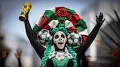 A woman dressed as a Catrina, an ancestor figure that dominates Mexican culture, holds up a replica of a World Cup before the start of a Guinness World Record attempt for the world's largest Mexican Wave in Mexico City. AFP