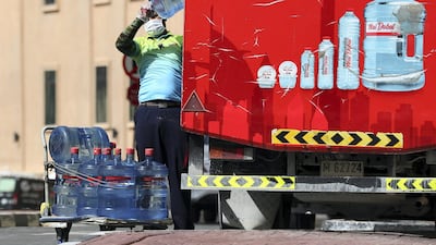 A delivery driver stacks water to provide to residents in an extremely quiet Jumeirah Beach Residence in Dubai. Chris Whiteoak / The National