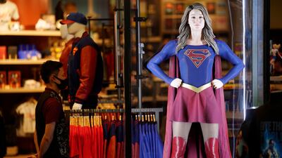 An authentic Supergirl costume is displayed behind glass.