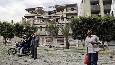 Yemenis stop and look up in front of a building heavily damaged in intensified Saudi-led coalition airstrikes on Sanaa on September 5.EPA