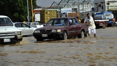 A Saudi man pushes his car in flooded water following heavy rainfall in the Saudi Arabian port city of Jeddah on November 17, 2015. AFP Photo