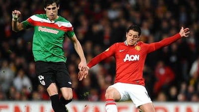 Athletic Bilbao's midfielder Javi Martínez, left, holds off the challenge ofManchester United's Javier Hernández.