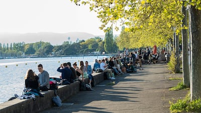 People sit outside by the lake Leman in Lausanne. Getty Images