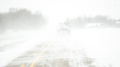 Snow blows over an icy road in North Liberty, Iowa. AP