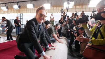 Conan O'Brien, host of Sunday's 97th Academy Awards, helps to roll out the red carpet for the show at the Dolby Theatre in Los Angeles. AP