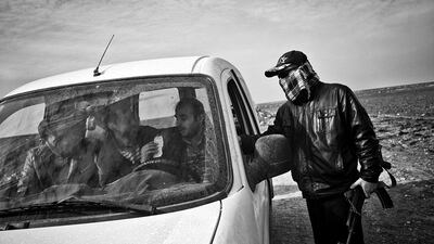 Afram Danho stops a car at a checkpoint. Some of the militia members are also part of the Sutoro, a Christian Assyrian/Syriac militia which is the armed wing of the Syriac Union Party. Some of the Sutoro members are suspected to be former shabiha and state collaborators with existing ties to the Government security forces.