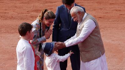 Mr Modi greets Mr Trudeau's son Hadrien during the ceremonial reception for his father. Adnan Abidi / Reuters
