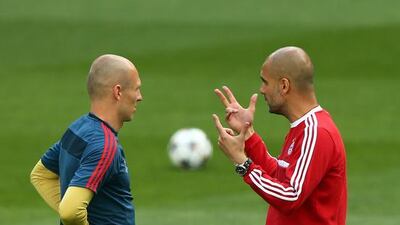 Head coach Pep Guardiola (R) talks to Arjen Robben during their FC Bayern Muenchen training at the Santiago Bernabeu Stadium ahead of the UEFA Champions League semi-final first leg match against Real Madridon April 22, 2014 in Madrid, Spain. Martin Rose/Bongarts/Getty Images