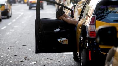 A taxi driver rests inside his vehicle as several taxis block some traffic lanes of a main avenue on a new day of taxi strikes in downtown Barcelona. Quique Garcia/EPA