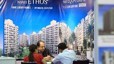 Indian expatriates meet with a salesman in December at the Nyati Ethos stall at the Indian Property Show at the Dubai World Trade Centre. Ravindranath K / The National