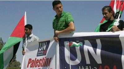 Activist hold banners promoting the Palestinian bid for a state of Palestine as the 194th member of the United Nations in front of the UN headquarters in the West Bank city of Ramallah yesterday. Majdi Mohammed / AP Photo