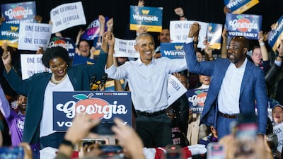 Mr Obama with Ms and Mr Warnock last week in Georgia. Getty / AFP