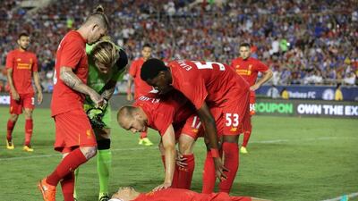Liverpool defender Dejan Lovren, on the floor, is surrounded by concerned teammates after colliding with his own goalkeeper while clearing a cross. Mike Nelson / EPA
