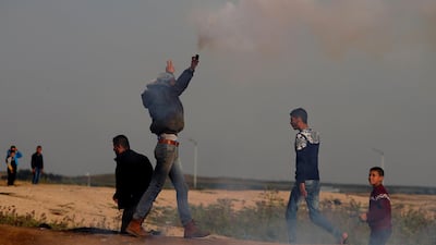 A Palestinian demonstrator holds a tear gas canister fired by Israeli troops during a protest at the Israeli-Gaza border fence, east of Gaza City on March 29, 2019. Reuters