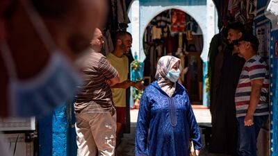 A Moroccan woman, wearing protective face mask, walks on a street in Tangiers' Old City, after the re-introduction of restriction measures to contain the coronavirus. AFP