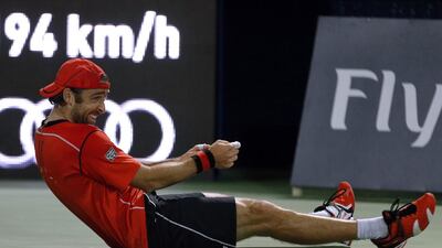 Benjamin Becker of Germany sits on the court during his match against Roger Federer of Switzerland on the first day of the ATP Dubai Duty Free Tennis Championships on February 24, 2014. Federer beat Becker 6-1, 6-4. AFP PHOTO/KARIM SAHIB